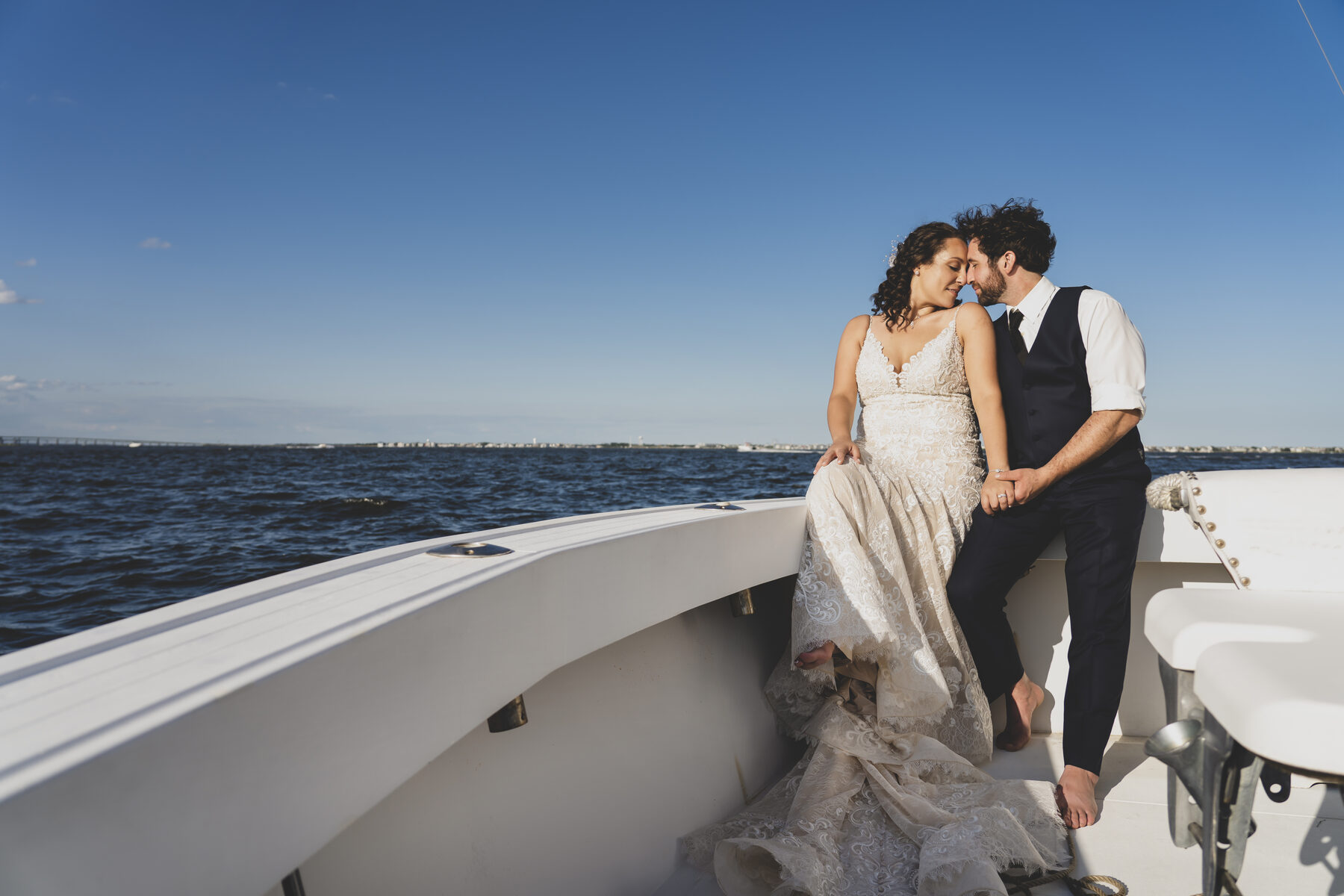 Newlyweds on a boat at dusk over the water